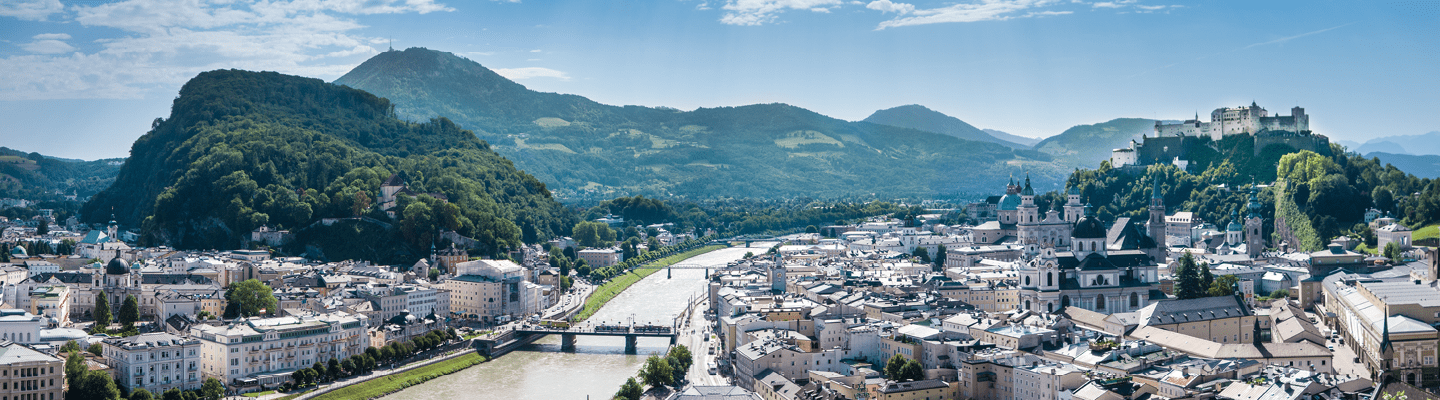 Panoramaaufnahme von Salzburg, die die historische Altstadt und die Festung Hohensalzburg eindrucksvoll präsentiert.